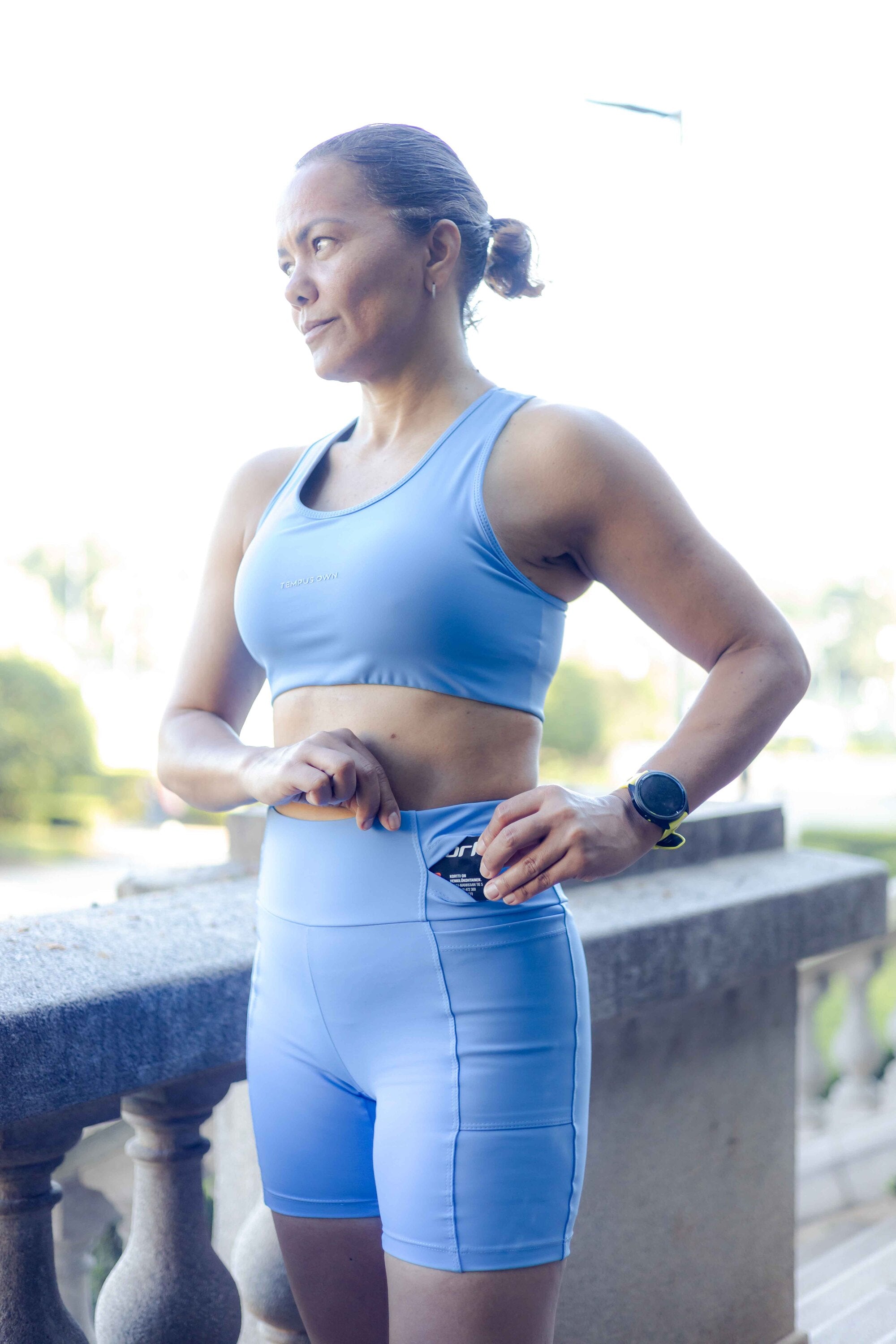 Light blue Tempus Own high-waisted running shorts with side pocket shown in use.
