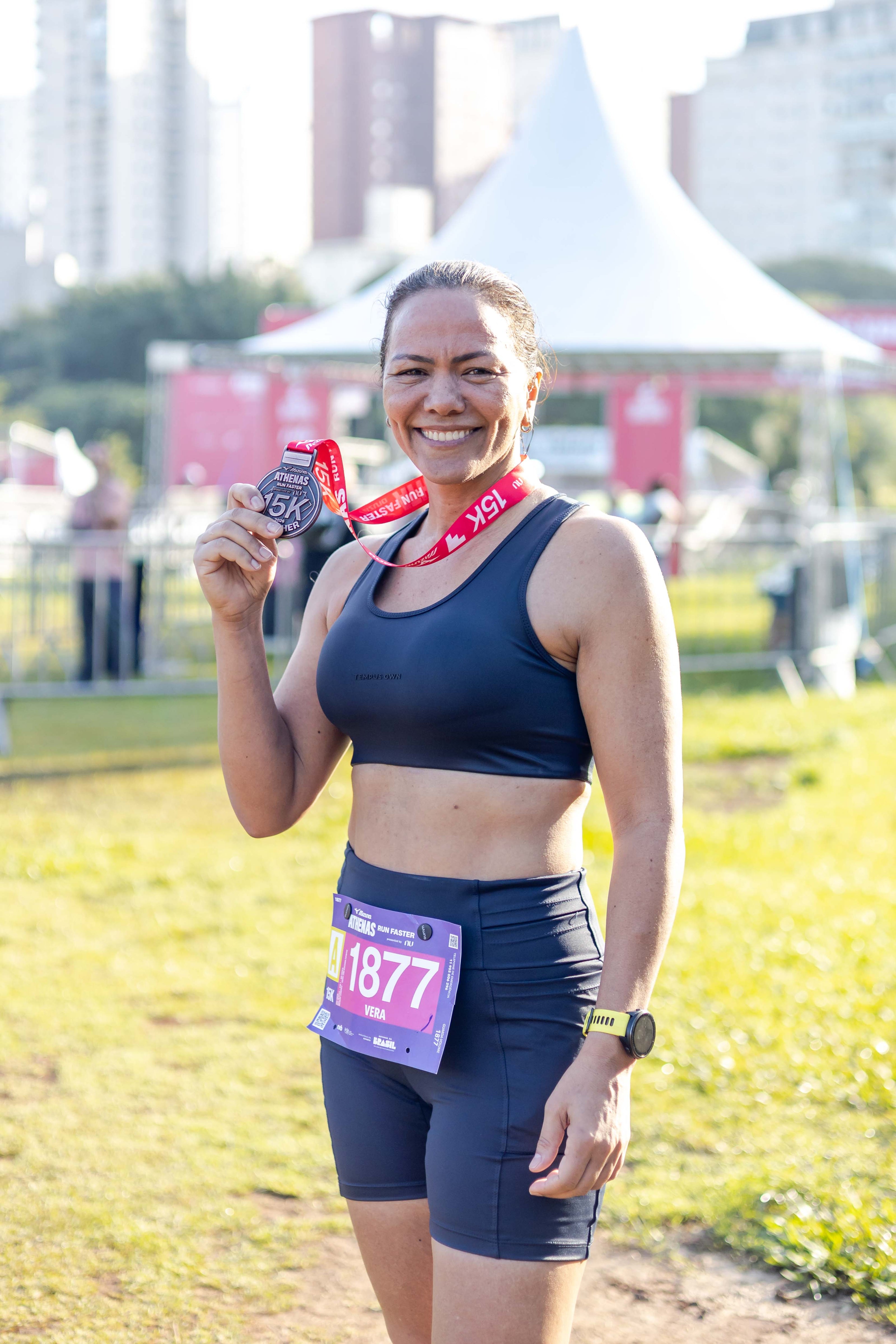 Woman wearing a Tempus Own sports bra and high-waisted running shorts on race day.